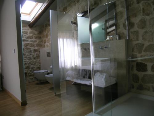 a bathroom with a glass shower and a toilet at Hotel Cresol in Calaceite