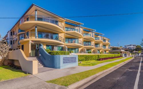 a yellow apartment building on the side of a street at The Cove Yamba in Yamba