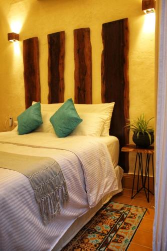 a bedroom with a bed with green and white pillows at Verde Morada in Valladolid