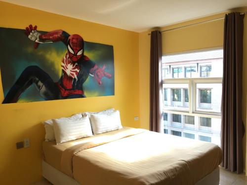 a bedroom with a spider man painting on the wall at Aubon Hostel in Bangkok