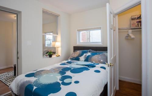 Schlafzimmer mit einem Bett mit einer blauen und weißen Bettdecke in der Unterkunft Charming studio - 3 min walk to PETWORTH Metro station; 10 min to Convention Center in Washington