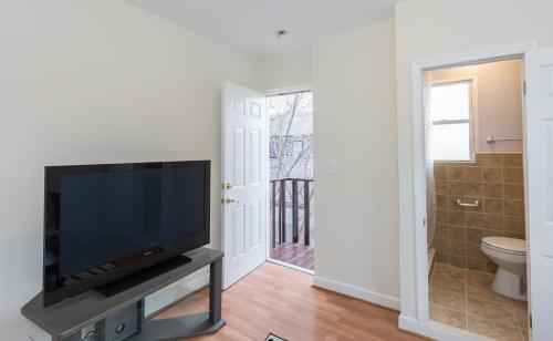 a living room with a flat screen tv on a stand at Charming studio - 3 min walk to PETWORTH Metro station; 10 min to Convention Center in Washington, D.C.
