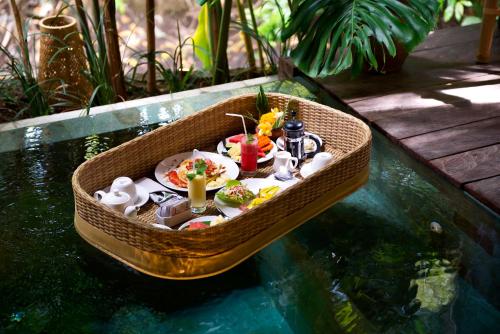 坎古卡拉帕瑜伽精品度假村 的水里的一艘小船，船上有食物。