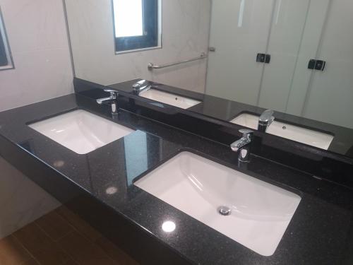 a bathroom counter with two sinks and a mirror at Venice Seaview Hotel in Xiaoliuqiu