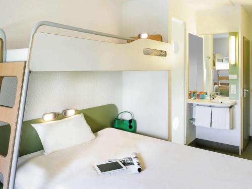 a room with a bed with a camera on it at Ibis budget München Airport Erding in Erding