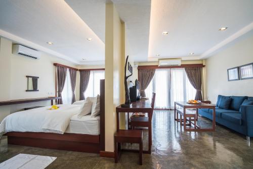 Retreat Siargao Resort في جنرال لونا: غرفة نوم بسرير واريكة زرقاء