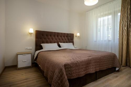 a bedroom with a large bed and a window at Vila Elegancija in Palanga