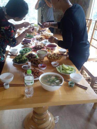 a group of people standing around a table with food at ChienDe Homestay in Sa Pa