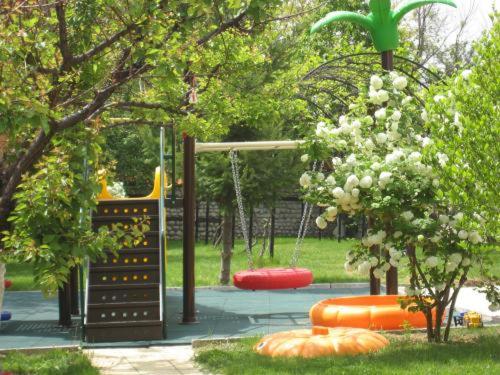 a park with a playground with a swing at Hotel Villa Ofir in Sandanski