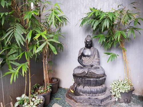 a statue of a buddha sitting on a fountain at Dragonfly Hotel - The Art Hotel in Mumbai