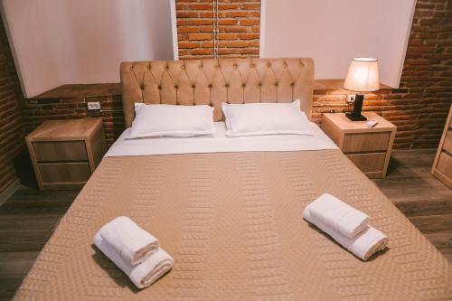 duże łóżko z dwoma poduszkami na górze w obiekcie Old Chache House w mieście Telawi