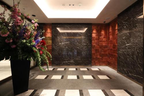 a lobby with a door with a vase of flowers at The Rise Osaka Kitashinchi in Osaka