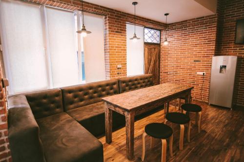 a dining room with a bench and a table and chairs at Old Chache House in Tʼelavi