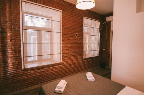 a bedroom with a bed and a brick wall at Old Chache House in Tʼelavi