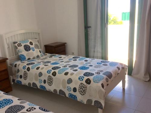 a bedroom with a bed with a comforter on it at Grand House "Cucharas Beach" in Costa Teguise