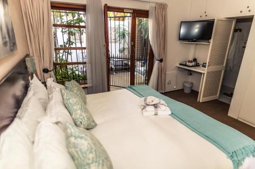 Un dormitorio con una cama con una toalla. en Point B Guest House, en Ciudad del Cabo