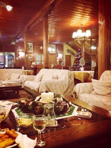 a living room with a christmas tree and a table at Hotel Koukouli in Souflíon
