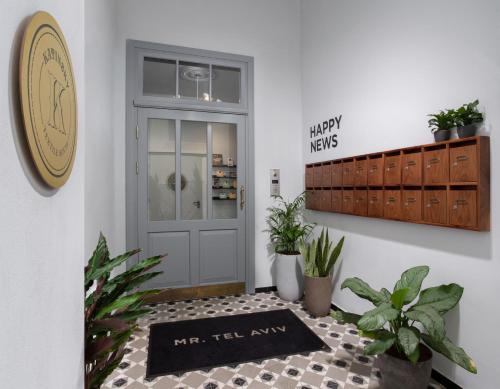 a welcome mat in front of a door with plants at Mr. Katinsky - By TLV2GO in Tel Aviv