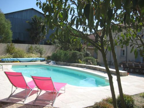 - deux chaises et une piscine dans la cour dans l'établissement Chambres d'hôtes de l'Abbaye, à Nieul-sur-lʼAutise