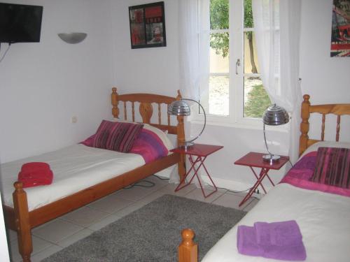 une chambre avec deux lits et une fenêtre dans l'établissement Chambres d'hôtes de l'Abbaye, à Nieul-sur-lʼAutise