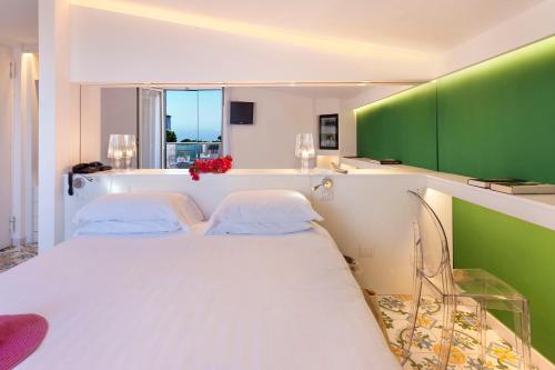 a bedroom with a white bed and a green wall at Hotel Alpha in Sant'Agnello