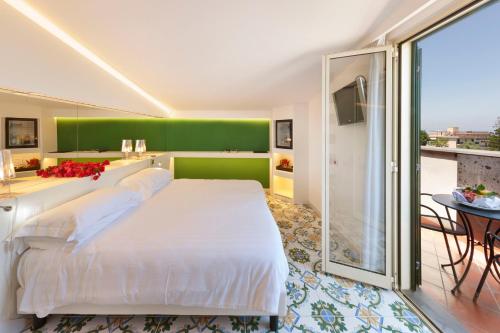 a bedroom with a white bed and a green wall at Hotel Alpha in Sant'Agnello