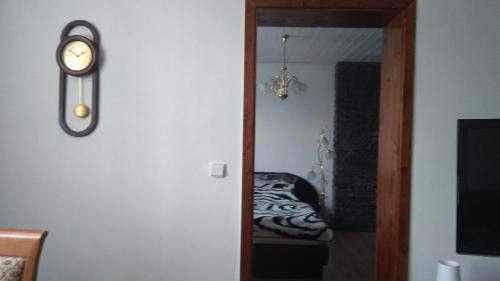 a hallway with a clock on a wall next to a bed at Apt.Jana ,apt.Terezka in Stožec