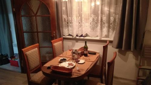 a dining room table with a bottle of wine on it at Apt.Jana ,apt.Terezka in Stožec