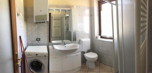 a white bathroom with a sink and a toilet at Monolocale Belvedere vda La Thuile CIR 0067 in La Thuile