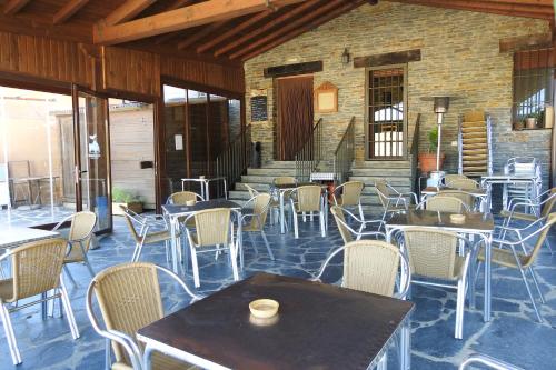 um restaurante com mesas e cadeiras e uma parede de tijolos em Casa Rural Monfragüe em Villarreal de San Carlos