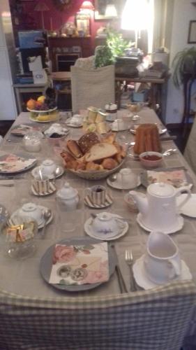 une table remplie de nourriture, d'assiettes et de théières dans l'établissement La Colline des Roses, à Colline-Beaumont