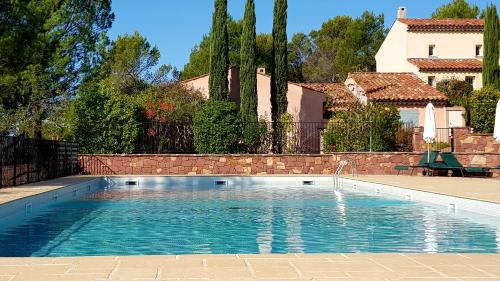 une piscine devant une maison dans l'établissement Villa au golf de St-Endréol, à La Motte