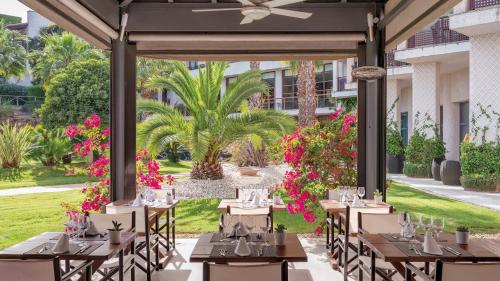 
a dining room with tables and chairs and flowers at Precise Resort El Rompido-The Hotel in El Rompido
