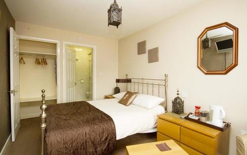 um quarto com uma cama grande e um espelho em Warwick Home From Home em Warwick