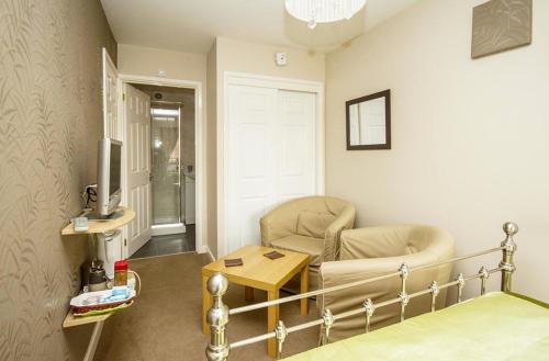 ウォリックにあるWarwick Home From Homeのベッド1台、椅子、テーブルが備わる客室です。