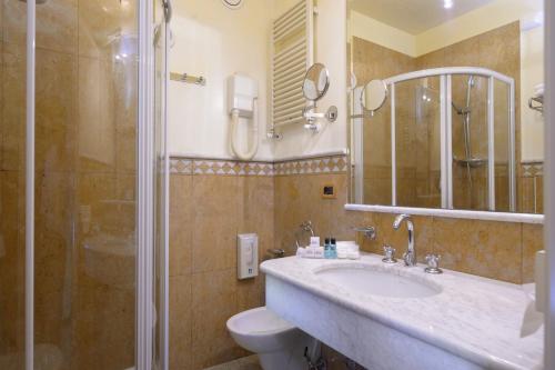 La salle de bains est pourvue de toilettes, d'un lavabo et d'une douche. dans l'établissement Hotel Bristol, à Sottomarina