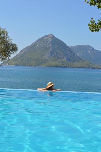 a person in a hat in a swimming pool at Thesmos Village in Mýtikas