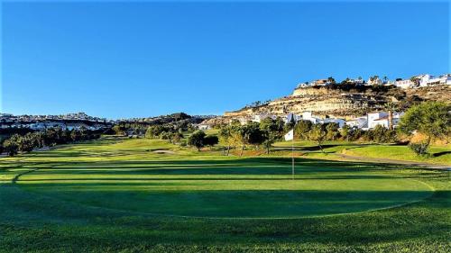 a green golf course with a hill in the background at Apartment Segura 2BD in Rojales