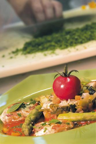a green plate of food with a tomato on it at Logis Hôtel restaurant des Pins in Bédoin