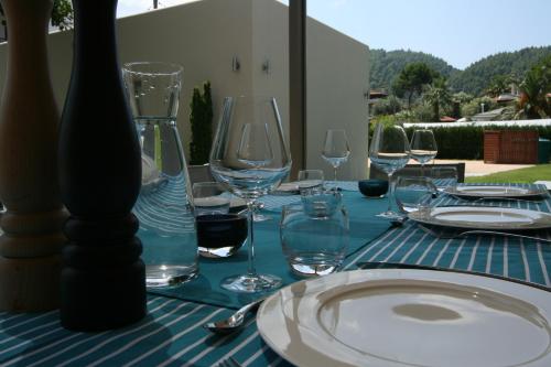a table with wine glasses and a plate on it at Tiamo Secrets - Beach Front in Vourvourou