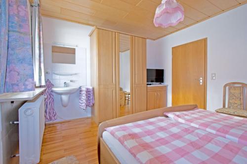 een slaapkamer met een bed en een wastafel bij Ferienwohnungen Anneliese in Neustadt an der Weinstraße