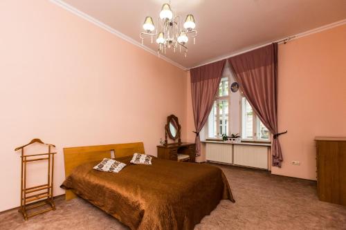 a bedroom with a bed and a chandelier at Apartment in the city centre in Lviv