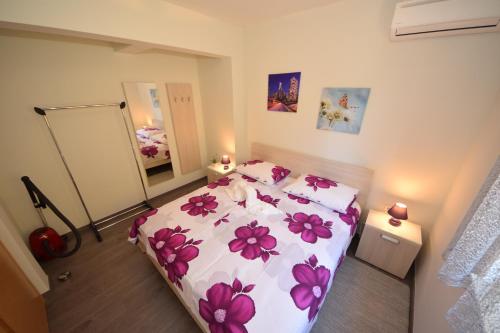 Un dormitorio con una cama con flores rosas. en Apartmani Dora i Kati, en Orebić