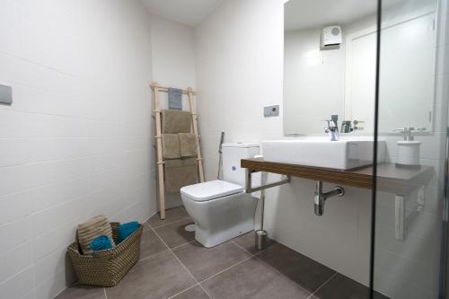 ein Badezimmer mit einem weißen Waschbecken und einem WC in der Unterkunft Maria Pita in A Coruña
