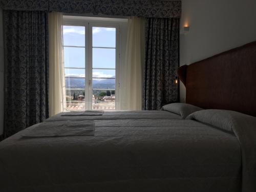 a bedroom with a large bed and a window at Hotel Don Miguel in Ronda