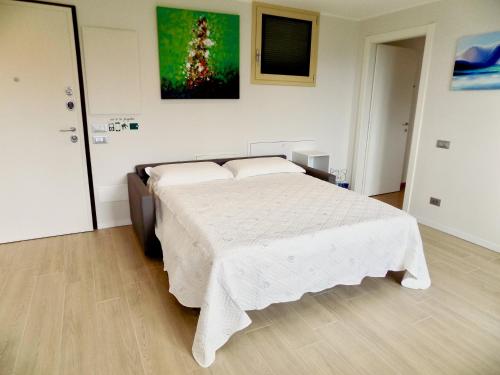 a bedroom with a large bed with a white blanket at Lake Como view Apartment in Como
