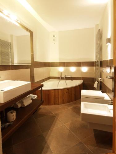 a bathroom with two sinks and a bath tub at Albergo Nazionale in Vernante