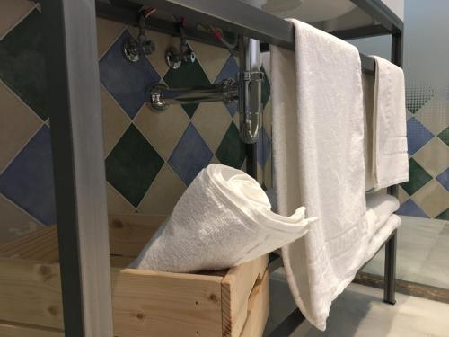 a bathroom with white towels hanging on a rack at Hotel Don Miguel in Ronda