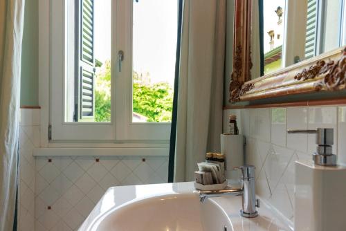 a bathroom with a sink and a mirror and a window at B&B a Ca' Minore Franciacorta in Passirano