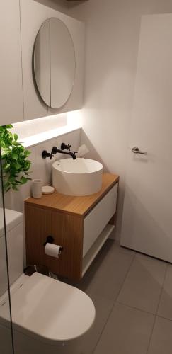 メルボルンにあるIvanhoe Apartmentsの洗面台、鏡、トイレ付きのバスルーム